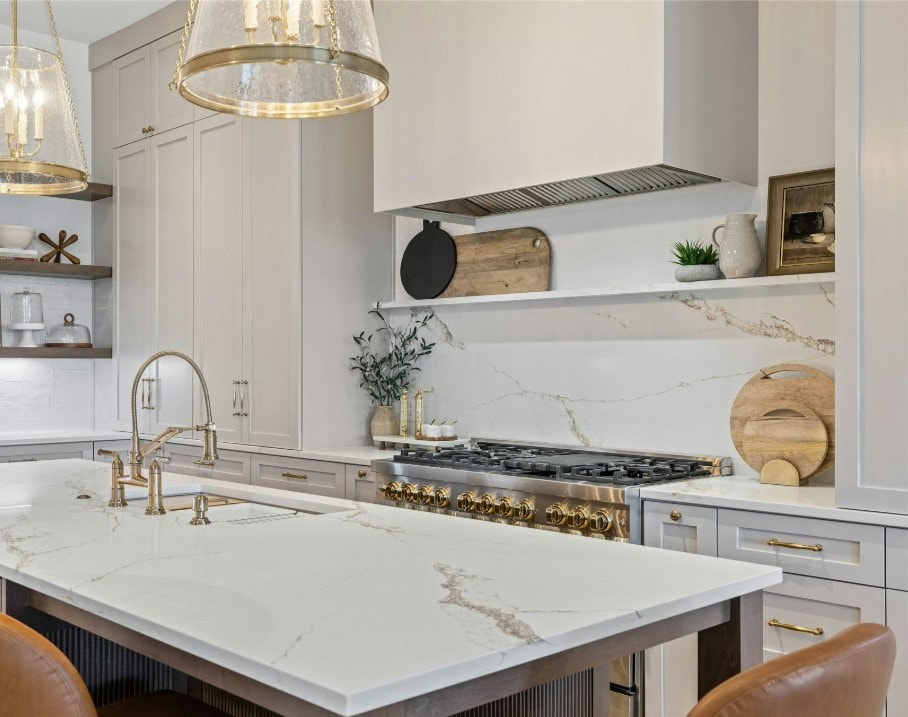 luxury kitchen with quartz countertops, gold lighting, range, island, shelf over range